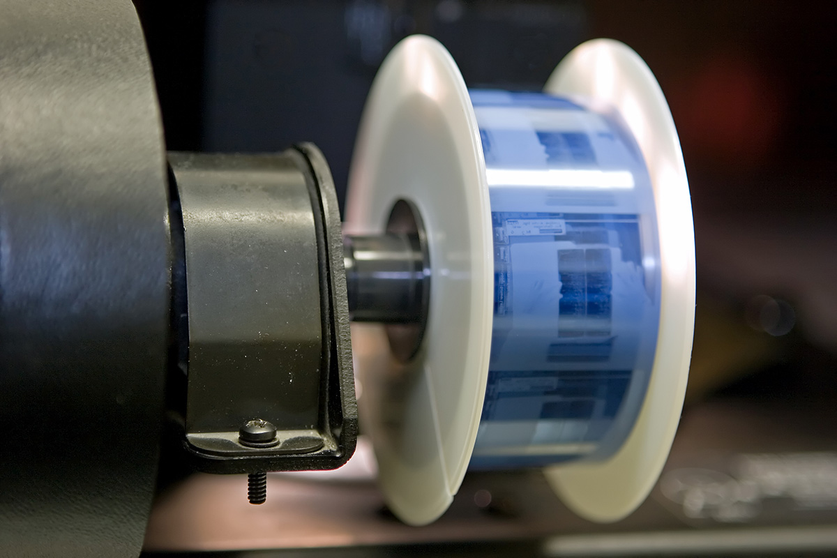 A roll of microfilm mounted on the spool of the film reader